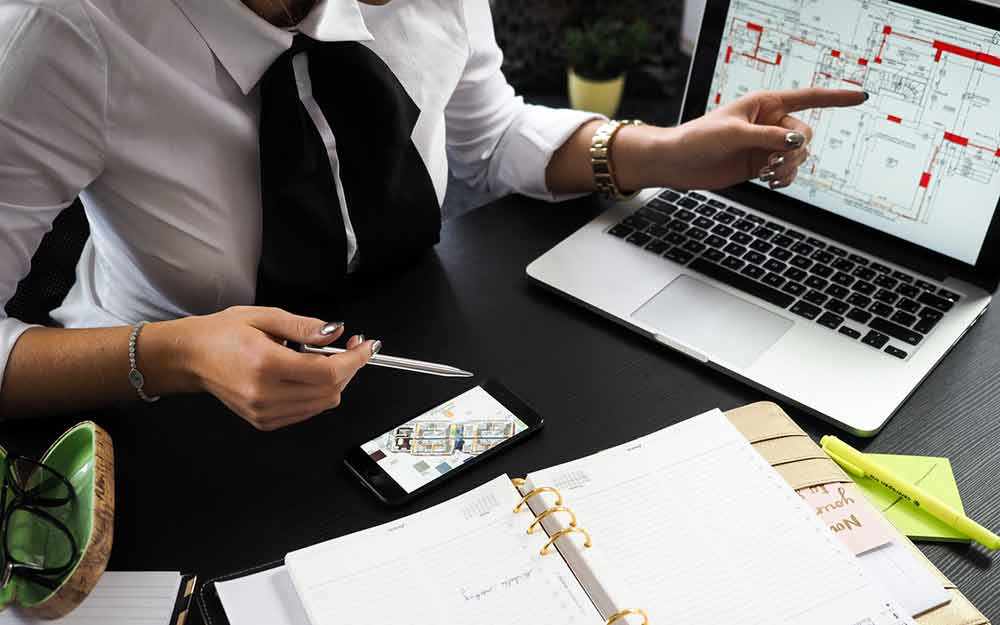 woman examining architectural drawing - WestmountMag.ca