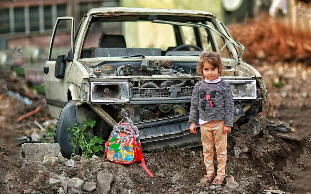 girl with backpack in war zone