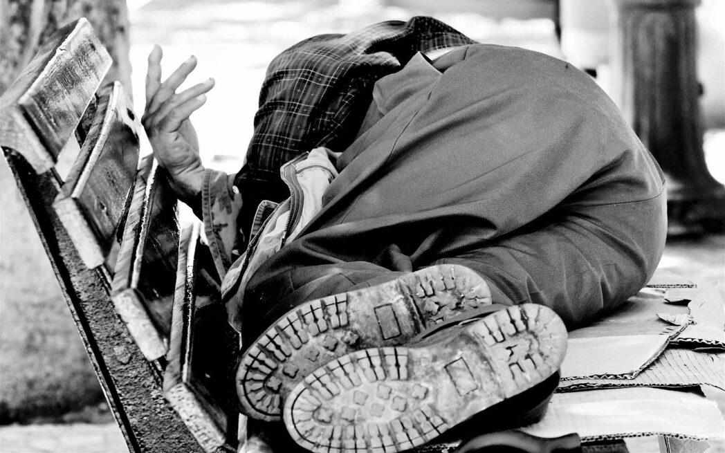 homeless person sleeping on cardboard
