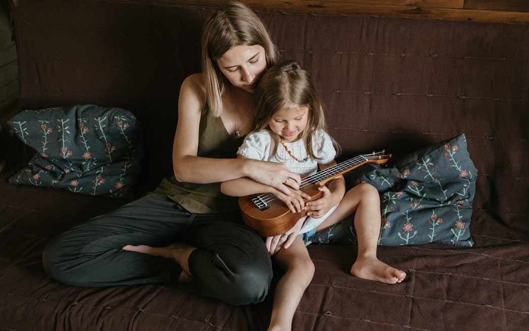 mother teaching guitar to daughter - WestmountMag.ca
