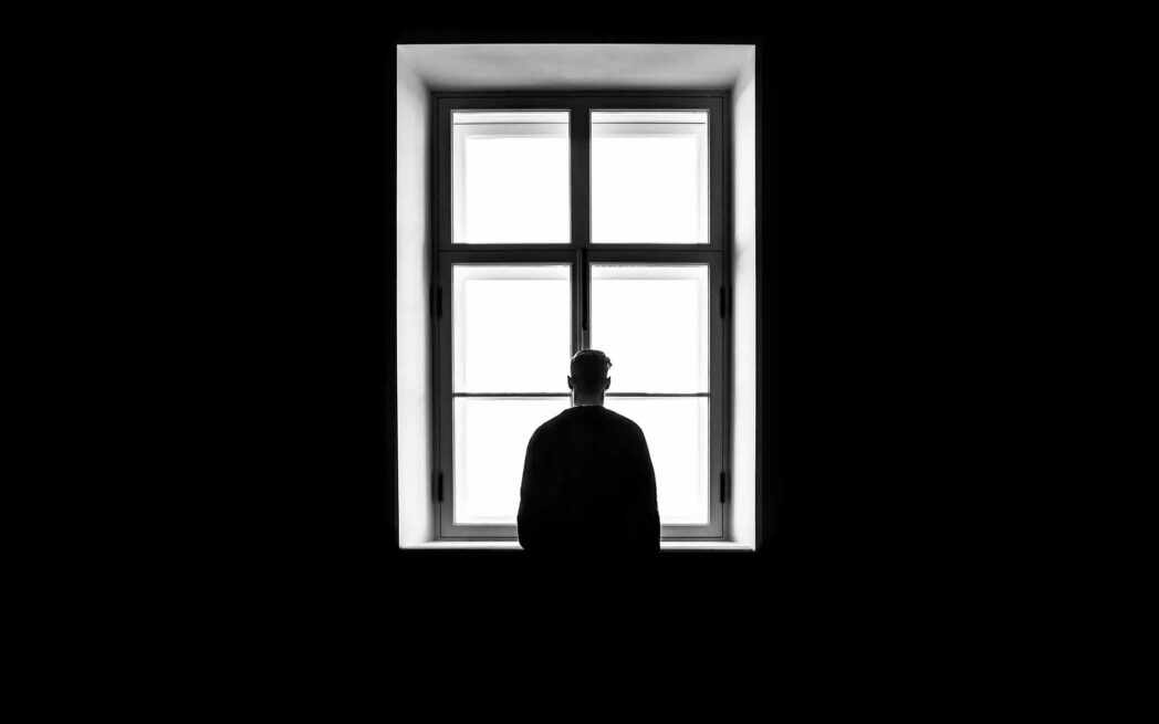 Worrying person looking out a window